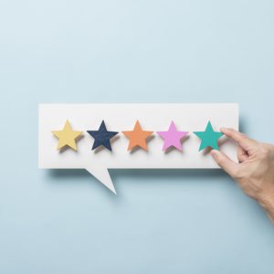 Five coloured stars on a speech bubble shaped board with a hand