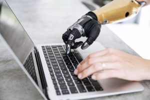 robotic hand and human hand on a keyboard