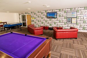 A communal living area with sofas and a pool table