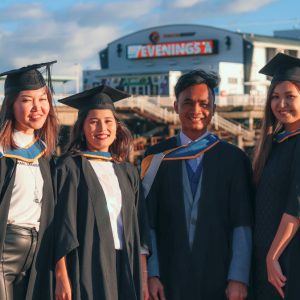 Four students at the beach on graduation day