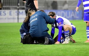 Injured footballer being looked at by physio