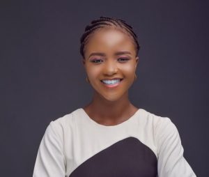 A head shot of international student Olamide, she wears a white and black top and a bright smile.