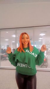 Student Esther poses in a bright green jumper on Talbot Campus