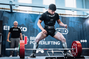 Lucas Silva getting into position to lift weights in a powerlifting competition