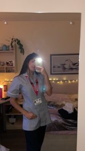 Maya taking a picture in the mirror in her nursing skills uniform for the first time
