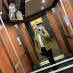 Will stands in a lift taking a selfie into the lift mirror