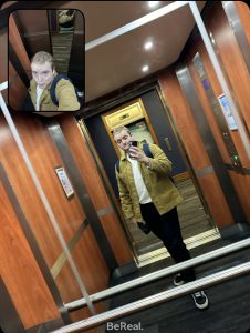 Will stands in a lift taking a selfie in the lift mirror