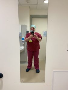 Zoe taking a mirror selfie in her scrubs