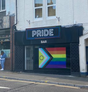 Photograph of Pride Bar building front with LGBT flag