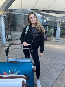 Student standing with luggage at the airport
