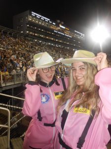 two students wearing pink jackets and cowboy hats