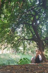 Kara meditating by tree