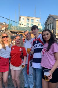 Mollie Filgate and friends smiling, stood outside with buildings behind them