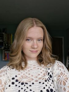 woman smiling with book shelves behind her