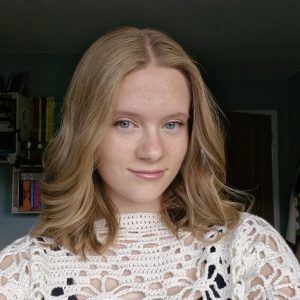 woman smiling with book shelves behind her