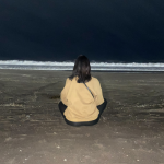 Student meditating at the beach