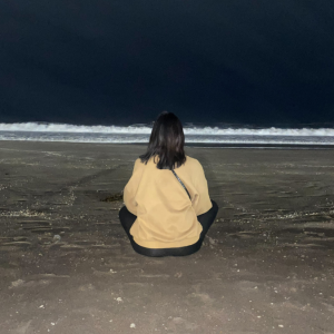 Student meditating at the beach