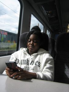 Aaliyah travelling by train while checking her phone